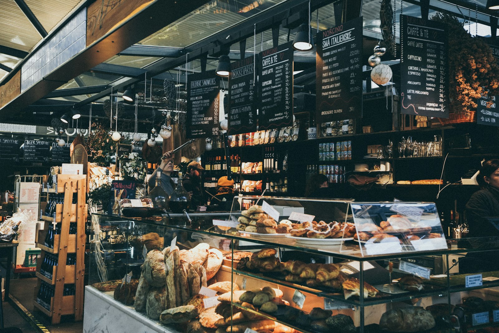A customer inside a bakery with pastries on display