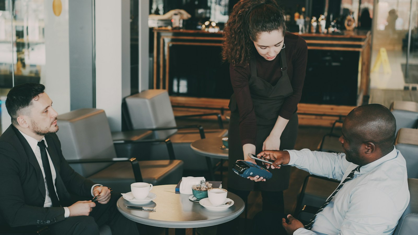 A customer paying by card at a café counter